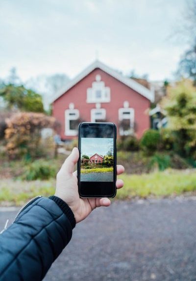 vertical-closeup-shot-person-taking-photo-traditional-red-house_181624-58540